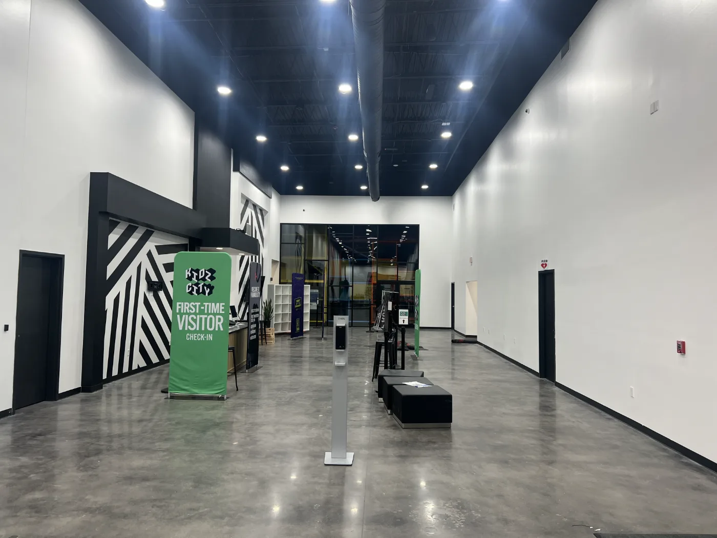 Gym lobby with white walls, black ceiling, and a painted graphic feature wall in Columbia SC