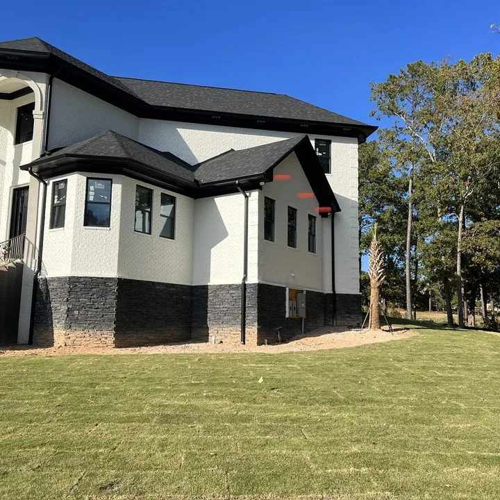 Finished exterior repaint on a large Midlands home with black trim and white brick