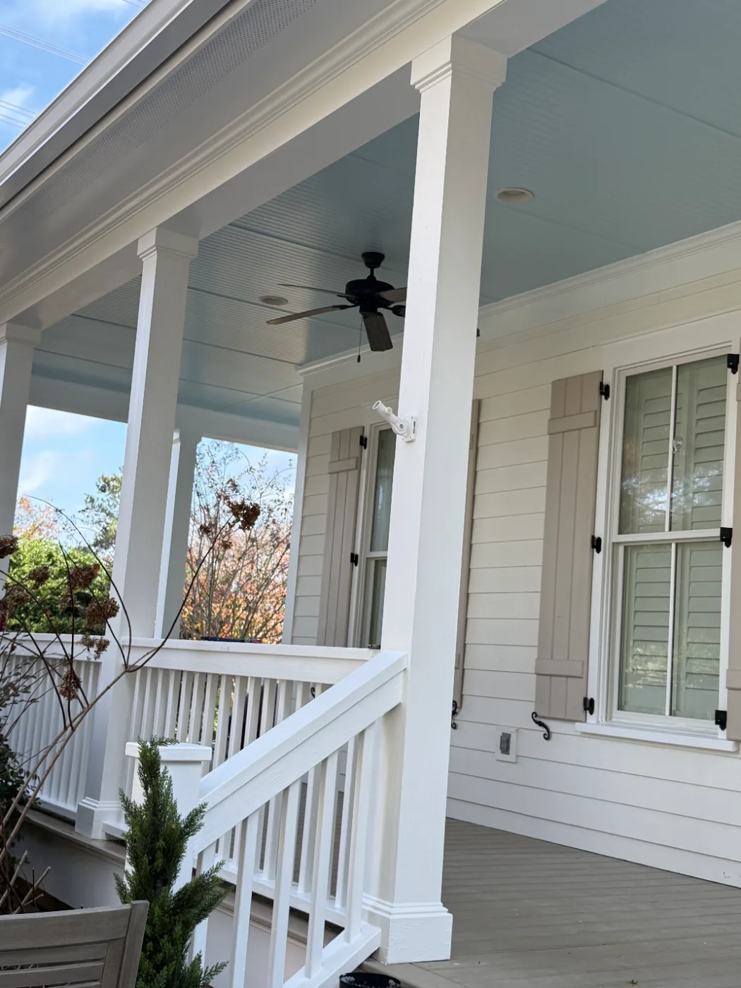 Front porch with painted ceiling, white columns, and railing on a home near Columbia SC